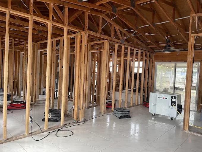 Industrial air movers and commercial dehumidifier running during active water damage structural drying in a Central Florida home
